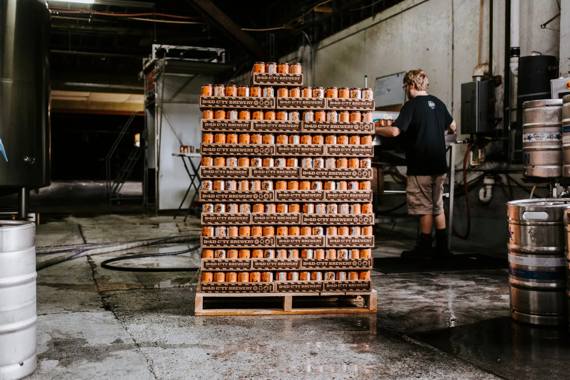 A shrink-wrapped pallet of cans on a warehouse floor