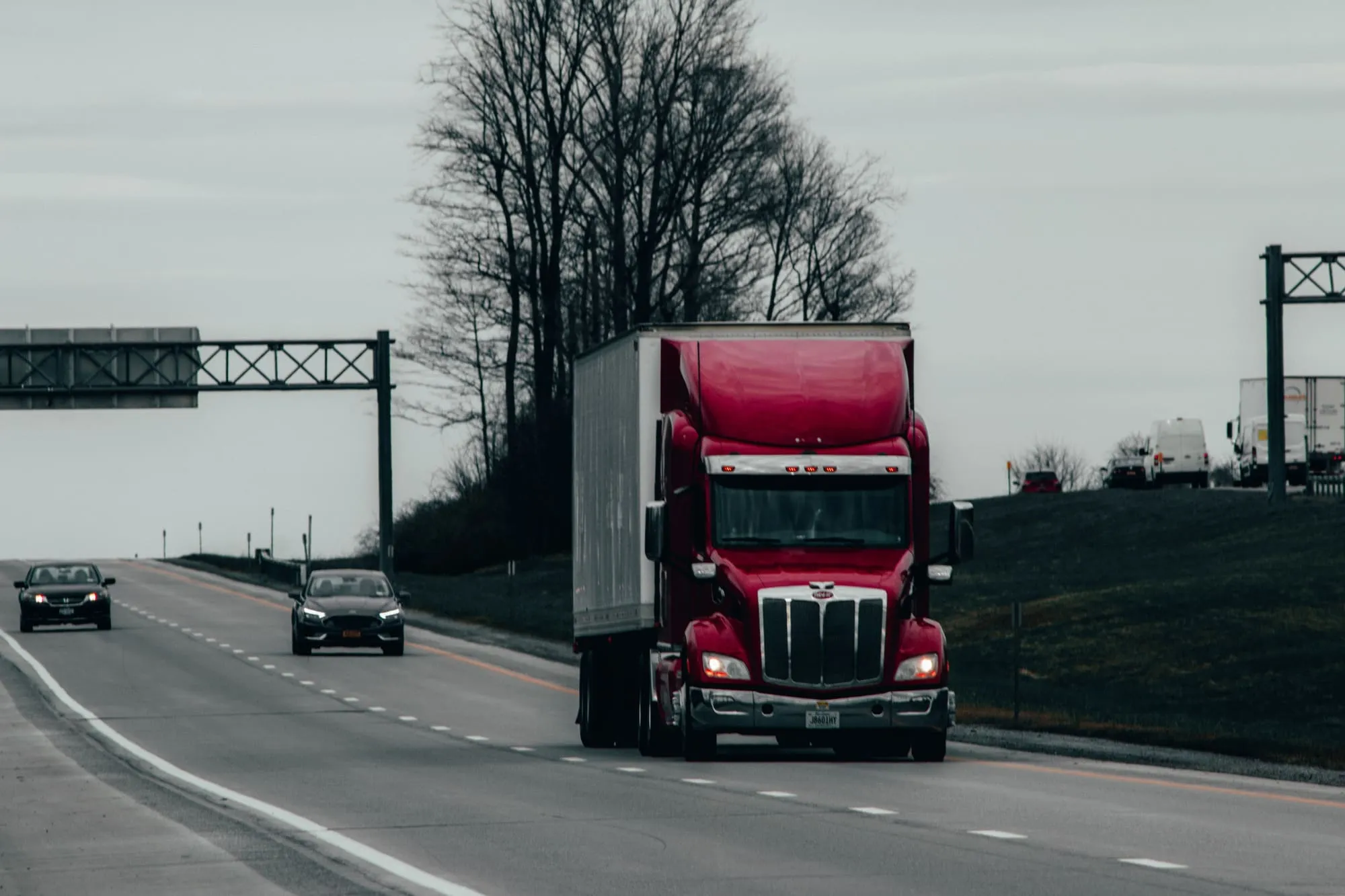 A red semi-truck on a divided highway