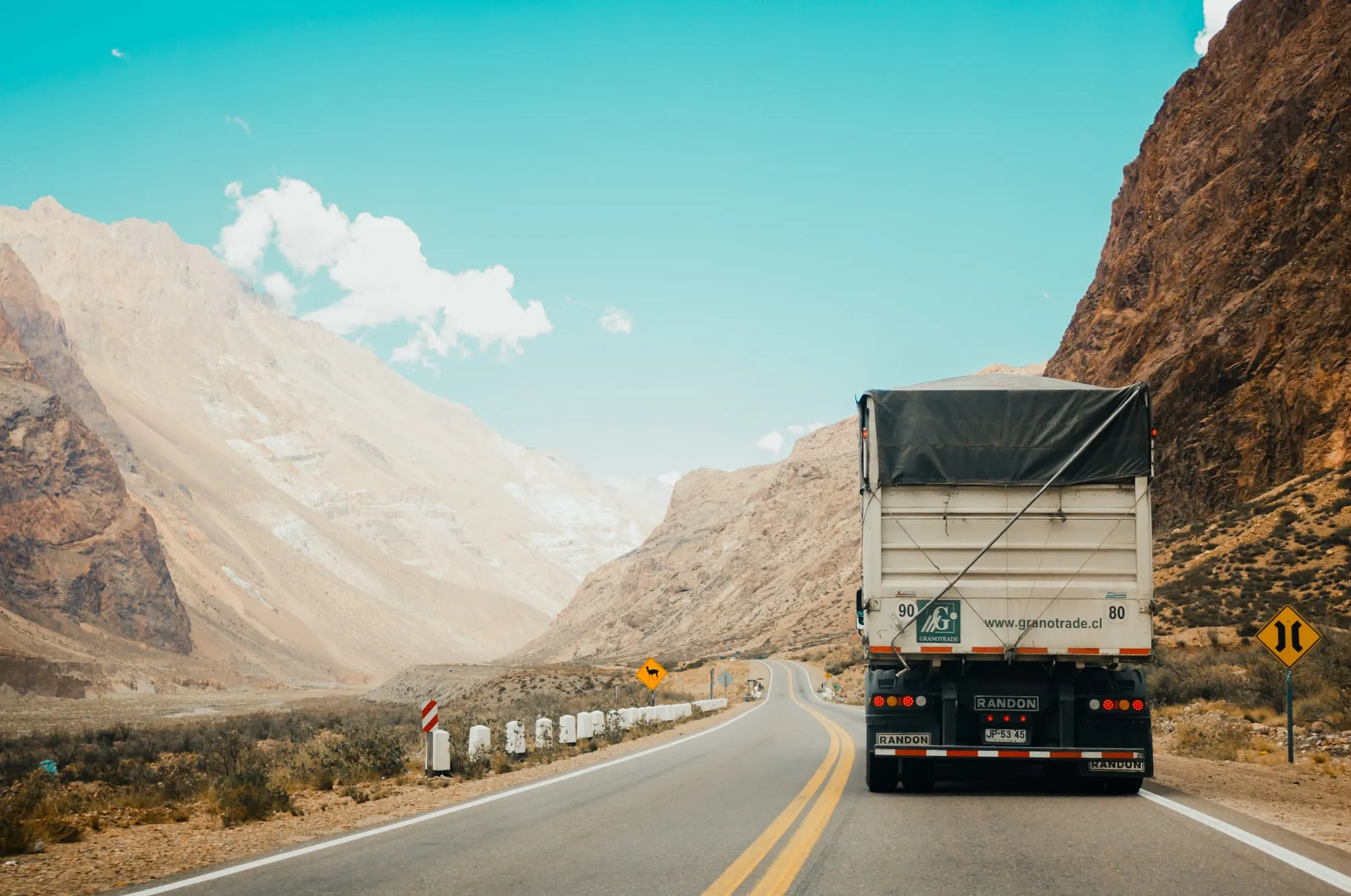 A covered cargo truck on a mountain highway