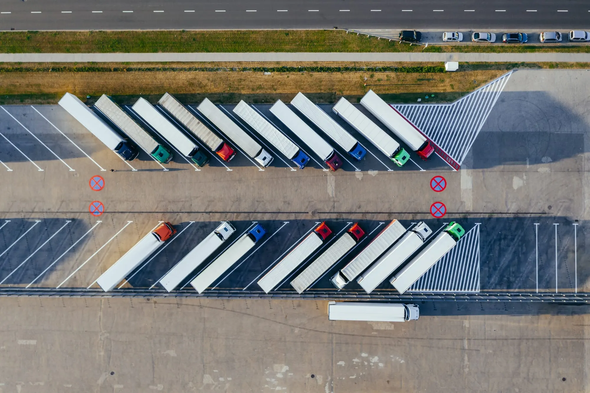 Tractor-trailers parked in rows at a freight yard, seen from above